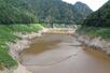 貯水率が0%になった早出川ダム。底辺部の水は残っている=4日、五泉市