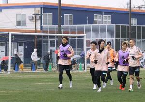 サポーターが見守る中、専用練習場で体を動かすDF早川史哉(一番右)ら=聖籠町