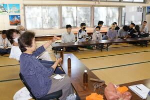 かつての植生などについて学生に説明する住民=胎内市桃崎浜