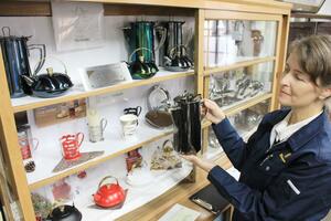 「小夜」シリーズの製品(棚の上段)を紹介する、玉虎堂製作所の柄沢マリア社長=燕市南4