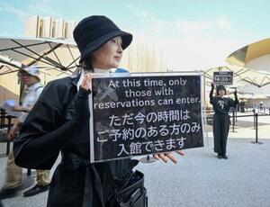 入館のためには事前予約が必要になることを伝える日本館のスタッフ=2日午後、大阪市此花区の夢洲