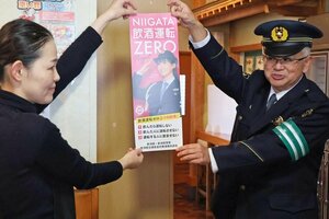 柏崎署などが飲食店を回って飲酒運転の根絶を呼びかける広報活動で、ポスターを手渡す山岸信行署長（右）と、受け取る店員＝柏崎市扇町