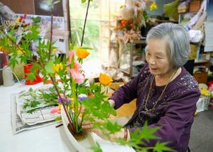 JR大村駅に飾るため、自宅で花を生ける笹山トヨ子さん=5月、長崎県大村市