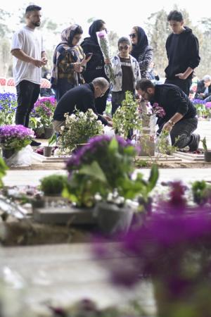 米イスラエルの攻撃が続くイランの首都テヘラン郊外の戦没者墓地を訪れた犠牲者の遺族ら=21日(共同)