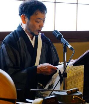 福岡大空襲の慰霊祭で犠牲者の氏名を読み上げる円応寺の三木英信副住職=14日午後、福岡市