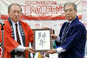 福島県に書家三藤観映さんが揮毫したラベル文字の原本を贈呈するのと共栄信用金庫の鈴木正俊理事長(左)=10月19日、福島県会津坂下町