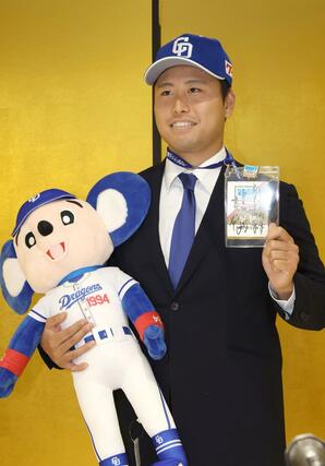 記念撮影する牧野憲伸＝新潟市中央区