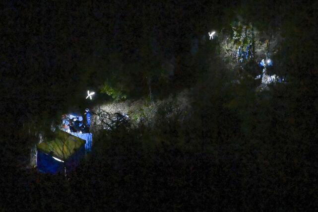 身元不明の遺体が見つかったとみられる京都府南丹市の現場付近を調べる捜査員ら＝１３日午後７時３８分（共同通信社ヘリから）