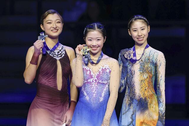 グランプリシリーズ初出場優勝を果たした中井亜美。左は２位の坂本花織、右は３位の住吉りをん＝アンジェ（共同）