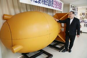 研究を重ねて制作した模擬原爆の実物大模型の前に立つ星貴さん=長岡市の長岡戦災資料館
