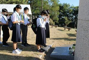 祈念碑に献花し、空襲の犠牲者を悼む参列者=8月10日、新潟市中央区