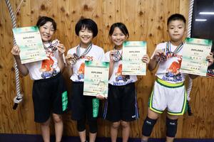 メダルと賞状を手にする（左から）内山琉梛さん、大地琴奏さん、長谷川綾音さん、佐藤氣斗さん＝新潟市西蒲区角田浜