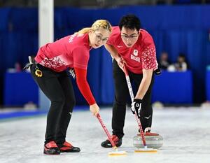 混合ダブルス1次L 韓国戦の第3エンド、スイープする小穴桃里(左)、青木豪=ケロウナ(共同)