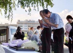 岐阜県可児市の豪雨災害から15年となり、モニュメントに向かい手を合わせる遺族ら=15日午後