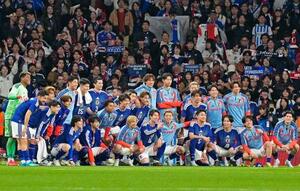 　サッカー国際親善試合でイングランドから初勝利を挙げ、サポーターと写真に納まる日本代表の選手たち＝３月３１日、ロンドンのウェンブリー競技場（共同）