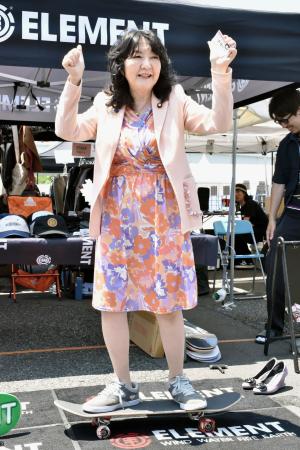 東京・お台場のイベントで、スケートボードに乗る片山財務相=16日午前