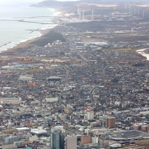 柏崎の市街地と柏崎刈羽原発(奥)。早期再稼働を求める請願は3月21日に市議会で採決される=2023年12月(本社ヘリから)