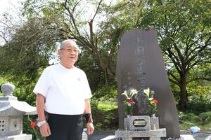 新たに設置した石碑の前で故郷への思いを語る神田清策さん=新発田市小国谷