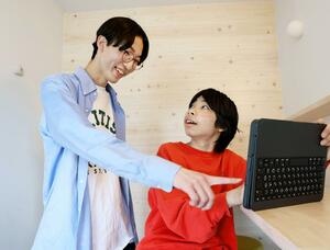 動画教材で学ぶ中学生に寄り添う横井悠希さん(左)=新潟市西区上新栄町5
