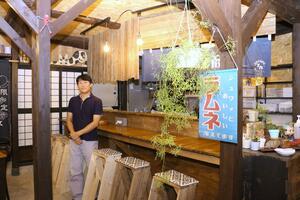 レトロな雰囲気のお好み焼き店。「店先でのたわいもない会話が楽しい」とほほ笑む福畠一良さん=佐渡市両津湊