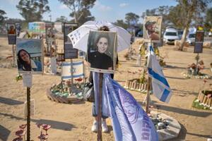 2日、イスラエル南部レイムでの抗議活動で「即時停戦を」と記された傘を持つ女性(AP=共同)