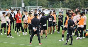 残り5試合となり、J1残留に向けた練習で入江徹監督の指示を聞く選手たち=聖籠町