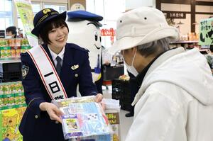 一日署長として啓発チラシやグッズを配布するMeguさん=新潟市北区かぶとやま