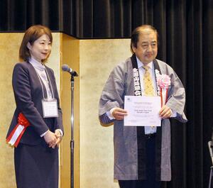 文化庁の小林万里子次長からユネスコ無形文化遺産登録の認定書を受け取った渡邉明村上まつり保存会会長（右）＝９日、村上市

