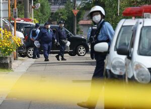 男性が殺害された現場へ到着した捜査車両と捜査員=6月7日、上越市
