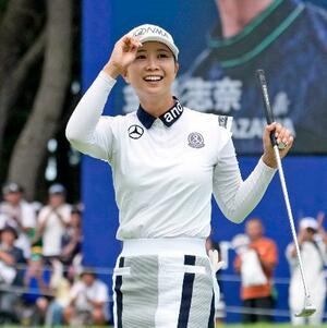 最終日、ウイニングパットを沈めギャラリーの声援に応える金沢志奈。通算10アンダーで優勝=大洗GC