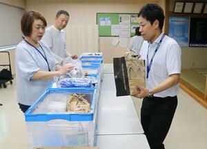 食品や日用品を寄付するコロナの従業員(右)=三条市東新保