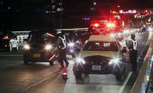 強盗未遂事件を受けて有明大橋周辺で検問を行う警察官＝６月１９日午後８時過ぎ、新潟市