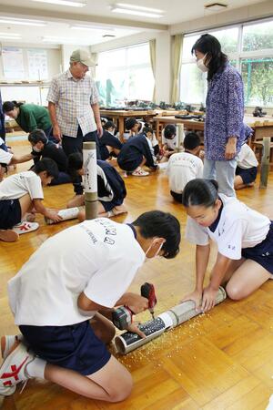 竹灯籠作りに励む三島中の生徒たち。最後の開催となる越後みしま竹あかり街道を彩る=長岡市吉崎