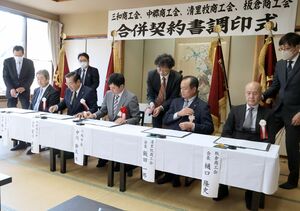 合併契約書に調印する板倉、三和、中郷、清里牧の4商工会の会長ら=11月14日、上越市牧区