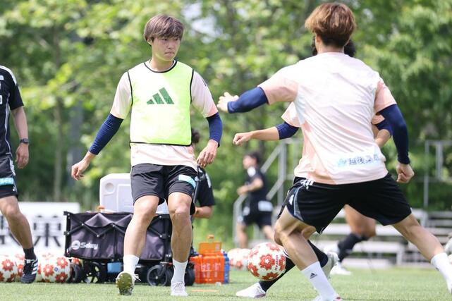 福山シティFC戦に向け、ボール回しをする新潟のDF岡本将成=6月10日、聖籠町