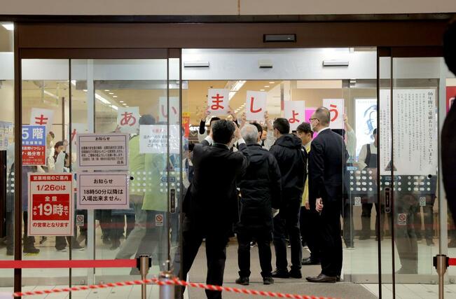 「またあいましょう」のカードを掲げる従業員＝１月２６日、新潟市中央区のイトーヨーカドー丸大新潟店