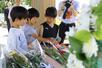 7・13水害の犠牲者を追悼し、黙とうをする小学生ら=13日、長岡市中之島の04中之島記念公園