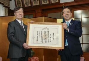 　滋賀県民栄誉賞を受賞し、表彰状を手にする大阪大の坂口志文特任教授。右は三日月大造知事＝２２日午前、県庁