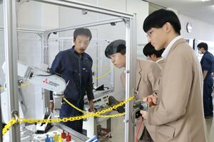 高校生が産業用ロボットの操作などを体験した施設見学会=新発田市新富町1