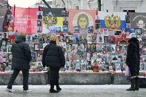 死亡したロシア兵らの追悼碑を見る人たち=7日、モスクワ(共同)