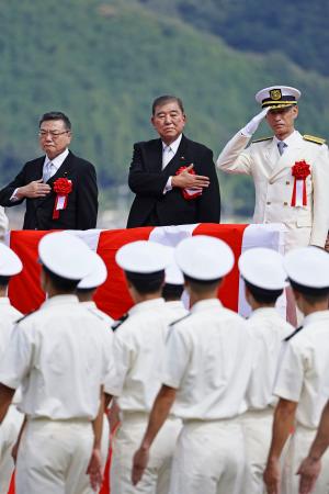 京都府舞鶴市の海上保安学校で、卒業生らの行進を見守る石破首相(中央)=27日午前