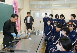 講演の後、ジビエ料理を振る舞う布施真さん(左)=新発田市下羽津