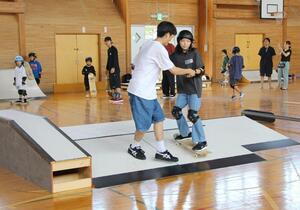 旧寺社小学校の屋内運動場でスケートボードに挑戦する児童ら=阿賀野市寺社