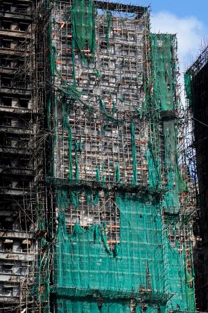 大規模火災が起きた香港の高層住宅群の外壁に残る防護ネット=29日(共同)