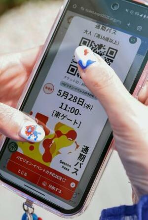 スマホ画面に表示された北纓真弓さんの通期パス。ネイルも「ミャクミャク」=5月、大阪市此花区の夢洲