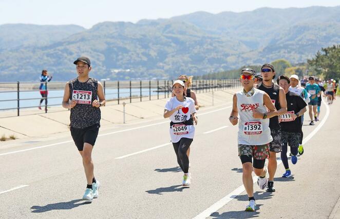 佐渡トキマラソンで両津湾沿いを駆け抜けるランナー＝２６日、佐渡市