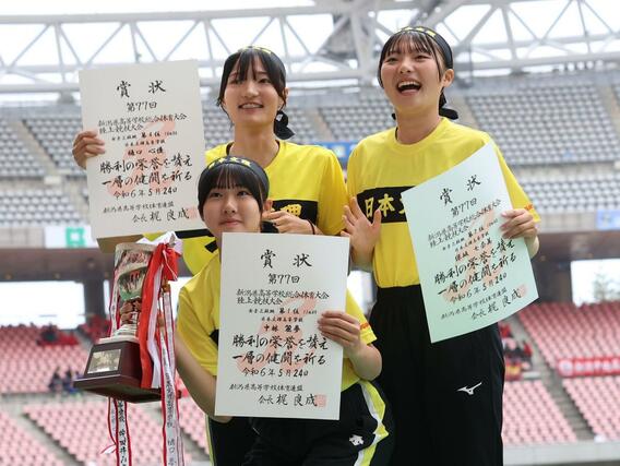 女子三段跳決勝 表彰台で笑顔を見せる優勝した中林麗夢(中央)ら日本文理の選手たち=デンカビッグスワン