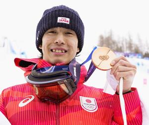 男子モーグルで獲得した銅メダルを掲げる堀島行真＝リビーニョ（共同）