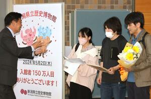 150万人目となり記念品を受け取る豊田由子さん一家=2日、長岡市関原町1