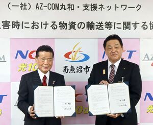 協定書を持つAZ-COM丸和・支援ネットワークの和佐見勝理事長(左)と林茂男南魚沼市長=5月31日、南魚沼市役所